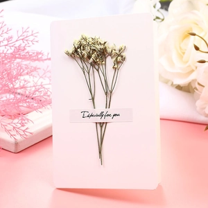 Close-up of a pink greeting card with dried flowers and Especially for you text