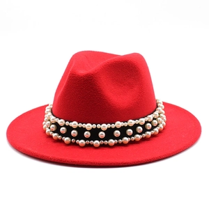 Detail of red wool fedora hat featuring black band with elegant white pearl embellishments
