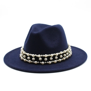 Detail of navy blue wool fedora with a black band featuring triple rows of white pearls