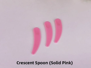 Detailed close-up of three pink crescent cosmetic spatulas for facial cream and mask application