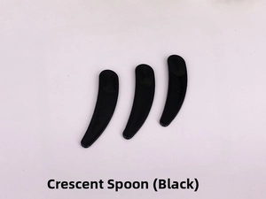 Three black crescent-shaped cosmetic spatulas for cream application on white background
