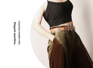 Detail of vintage carved double buckles on a brown leather belt worn with velvet pants