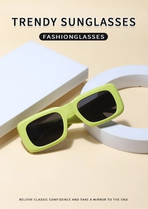 Detail of trendy avocado green rectangular sunglasses on minimalist geometric props