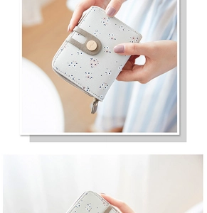 Close-up of women's mini floral zip wallet in grey-blue faux leather held in hand