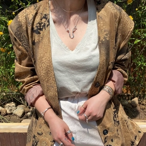 Detail showing 925 silver U-shaped pendant necklace with brown jacquard jacket