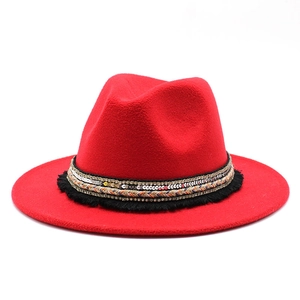 Detail of red wool felt fedora with ethnic sequin braid and tassel decorative band