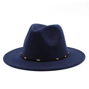 Detailed view of navy wool fedora with black ribbon and gold metal cylinder accents