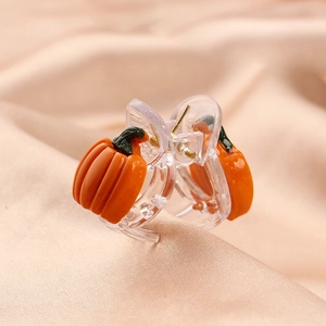 Cute orange pumpkin hair claw clip for girls on beige silk background, high quality accessory