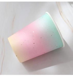 Detail of disposable paper cup with rainbow gradient and gold foil polka dots for parties