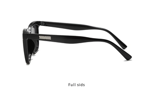 Detail view of black glossy sunglasses frame with silver metal logo on the temple