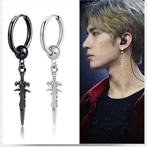 Close-up of vintage punk cross sword earrings in black and silver finishes on male model