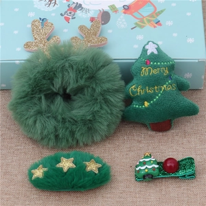 Detail of a 4-piece Christmas hair clip set with plush reindeer antlers and green trees