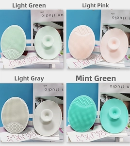 Silicone facial cleansing brushes in four pastel colors with soft bristles and suction grips