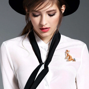 Cute fox shaped animal brooch in brown and gray pinned on a white shirt with hat