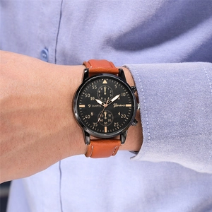 Classic black dial quartz watch with orange-brown leather strap on blue shirt sleeve
