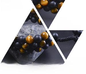 Detailed macro view of 8mm tiger eye and matte black stone beads on woven bracelet
