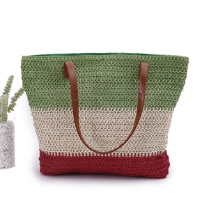 Detail of tricolor woven tote bag with green, beige, red stripes and brown leather straps