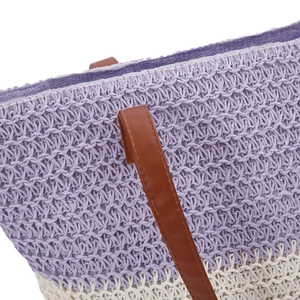 Detail of purple and white woven beach bag featuring brown leather shoulder straps