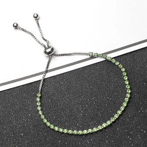 Macro detail of adjustable silver bolo bracelet with round green cut gemstones