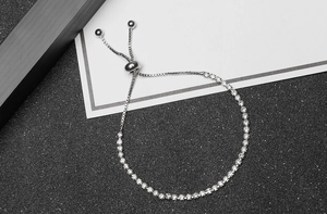 Detail of adjustable silver drawstring closure and cubic zirconia on box chain bracelet