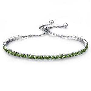 Detail view of silver adjustable bolo bracelet with sparkling round green rhinestones