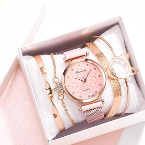 Close-up of pink dial quartz watch and three gold bracelets in a premium white gift box