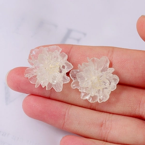 Detailed macro view of translucent white flower earrings with frosted resin petal texture