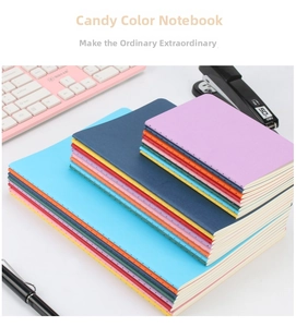 Close-up of colorful sewn binding notebooks in A5/B5 sizes on office desk with accessories