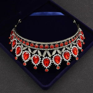 Detailed close-up of Baroque gold crown with red teardrop gems and rhinestones in blue box