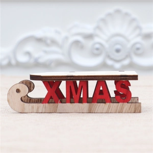 Detail eines hölzernen Weihnachtsschlitten-Dekos mit roten XMAS-Buchstaben auf Leinen