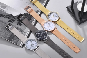 Detail of four quartz watches with marble dials and mesh metal straps in multiple colors
