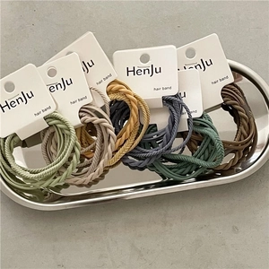 Five-pack of braided elastic hair bands in Morandi colors on a silver metal tray
