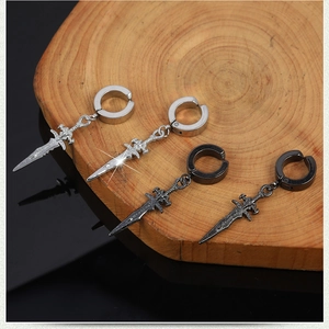 Macro shot of silver and black dagger earrings on a wood base with reflections