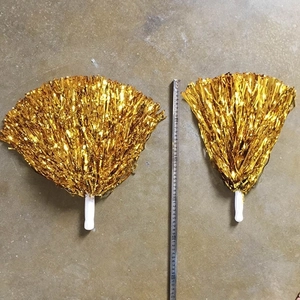 Detailopname van gouden cheerleading pompons met witte handvatten en 35cm maataanduiding