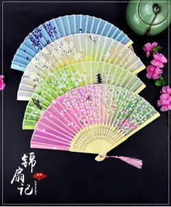 Classic folding fans with cherry blossom patterns, carved bamboo ribs, and silk tassels
