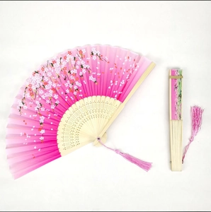 Detailed view of pink silk folding fan with cherry blossom pattern and pink silk tassel