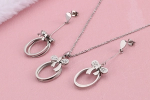 Close-up of silver bow jewelry set with crystals including necklace and earrings