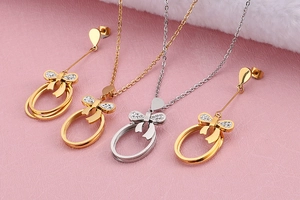Detailed view of gold and silver bowknot pendant necklaces with crystal inlay ornaments