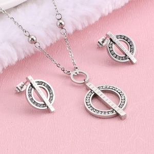 Polished silver stainless steel jewelry set with Roman numerals and crystals on pink background
