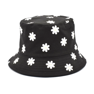 Détail de la broderie de marguerite sur un chapeau bob en coton noir avec coutures précises