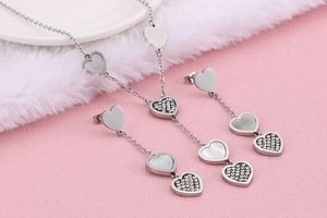 Detail view of silver heart necklace and earrings set with shell and sparkling rhinestones