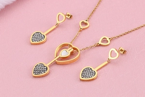 Détail de la parure cœur dorée avec strass sur une surface texturée rose
