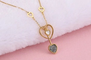 Gros plan détaillé d'un collier doré avec pendentif cœur et flèche sur fond doux