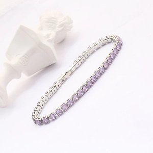 Detailed close-up of a silver tennis bracelet with circular cut purple zircon stones