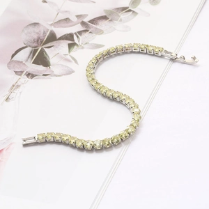 Silver hip hop tennis bracelet featuring light green zircons on a white minimalist background