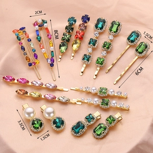 Detailed size chart of handmade crystal hair clips with pearls on pink silk fabric