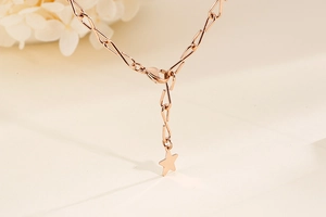 Detailaufnahme des roségoldenen Sternanhängers mit Karabinerverschluss und Kette