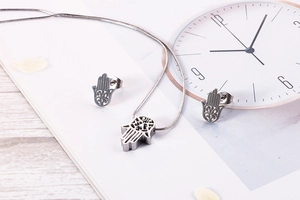 Detailed view of silver stainless steel Hamsa Hand necklace and stud earrings set