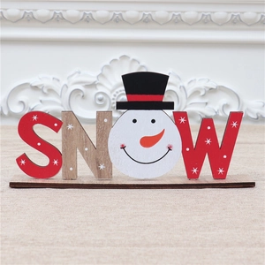 Macro shot of wooden SNOW letter ornament with red snowflake pattern and snowman head