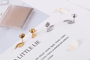 Detailed view of bird eye stud earrings in gold and silver finishes on a stylish card